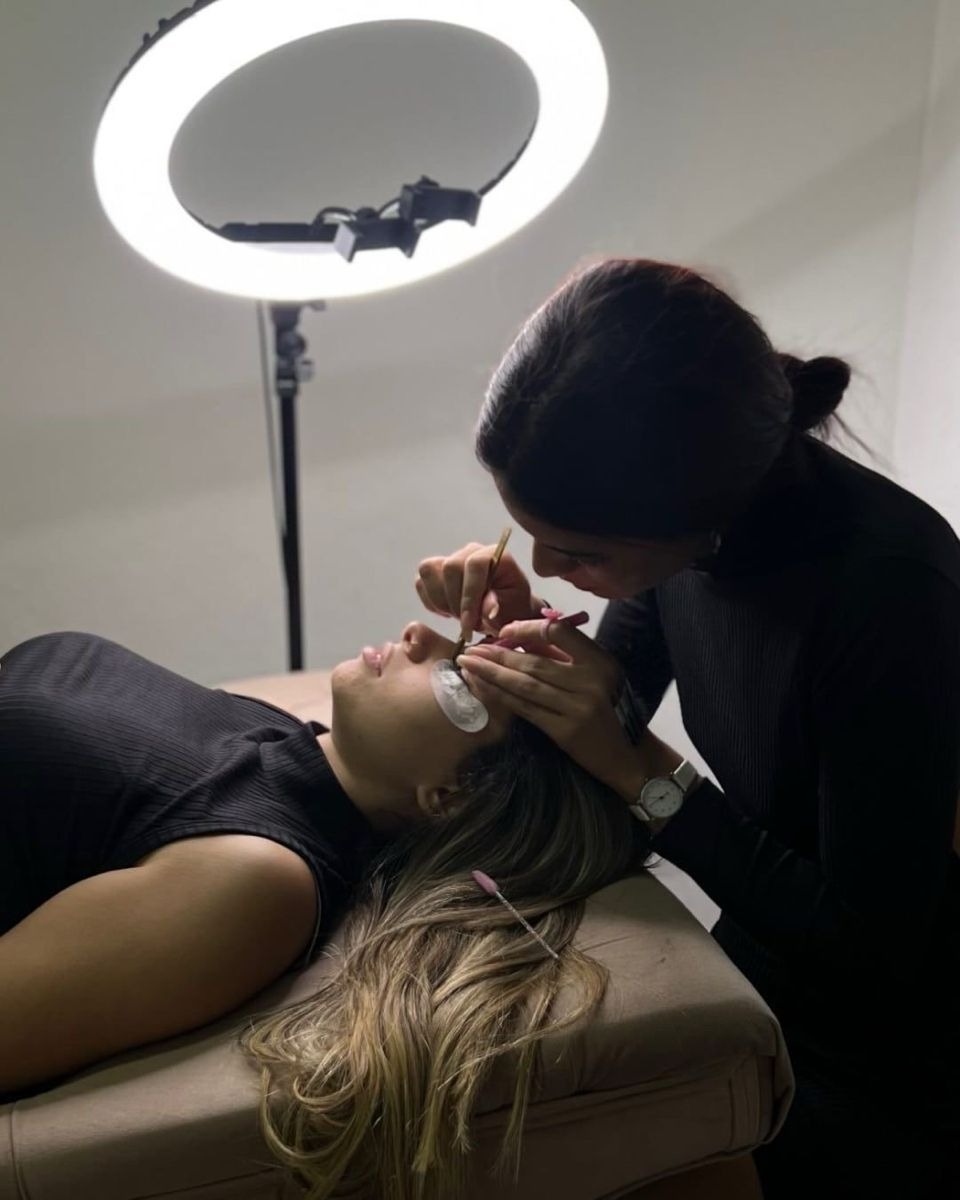 Profissional atendendo sozinha no studio, sob ring light