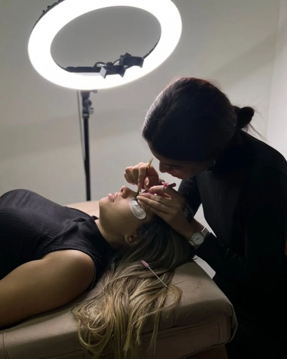 Profissional atendendo sozinha no studio, sob ring light